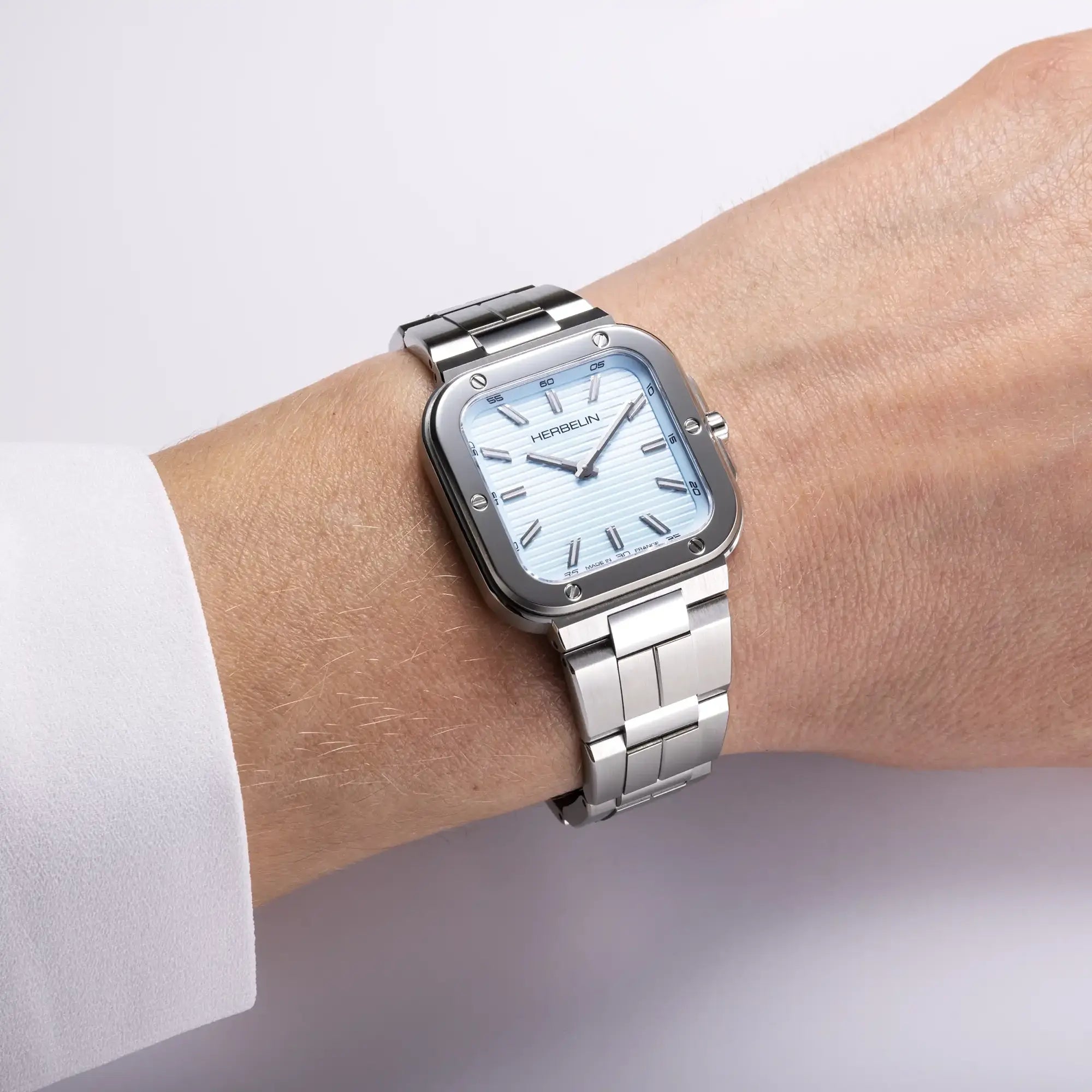 Au poignet féminin, cadran bleu arctique et bracelet acier visibles