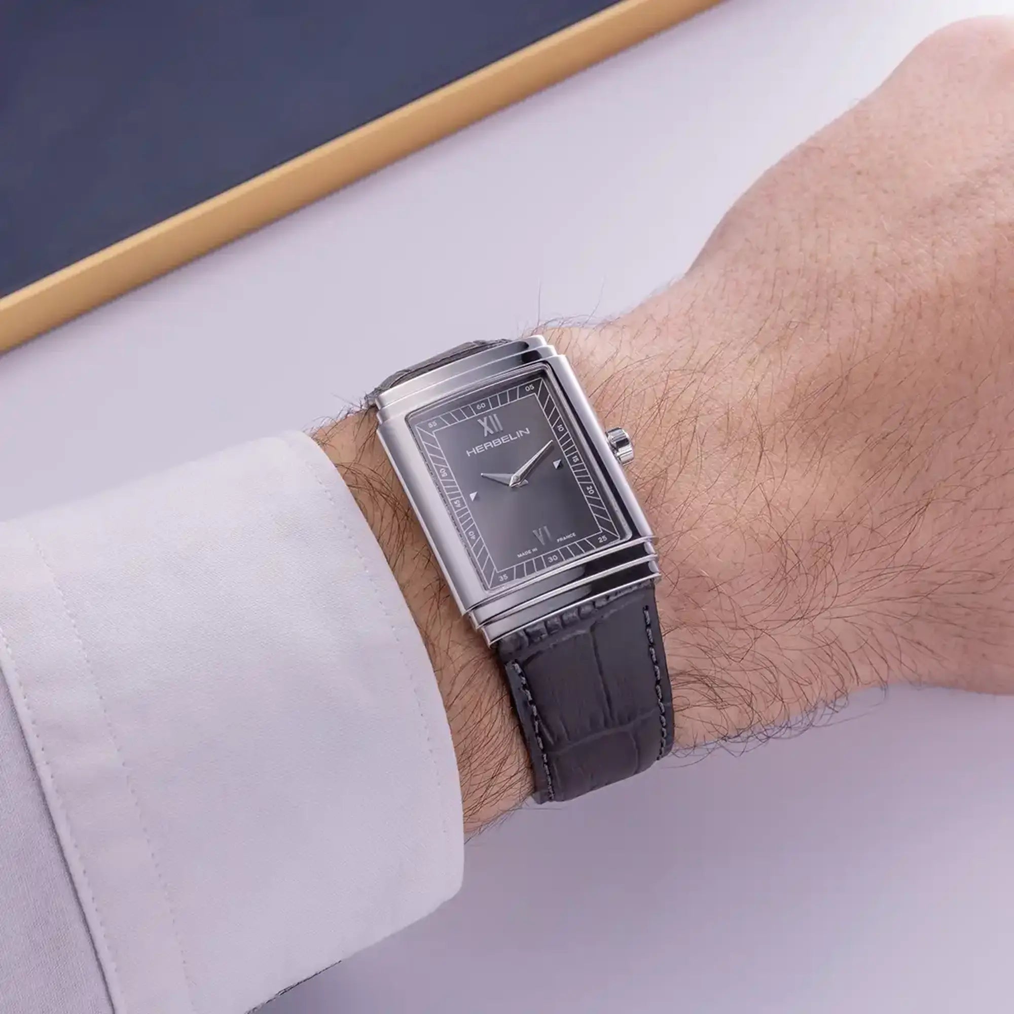 Au poignet masculin, cadran anthracite et bracelet cuir visibles