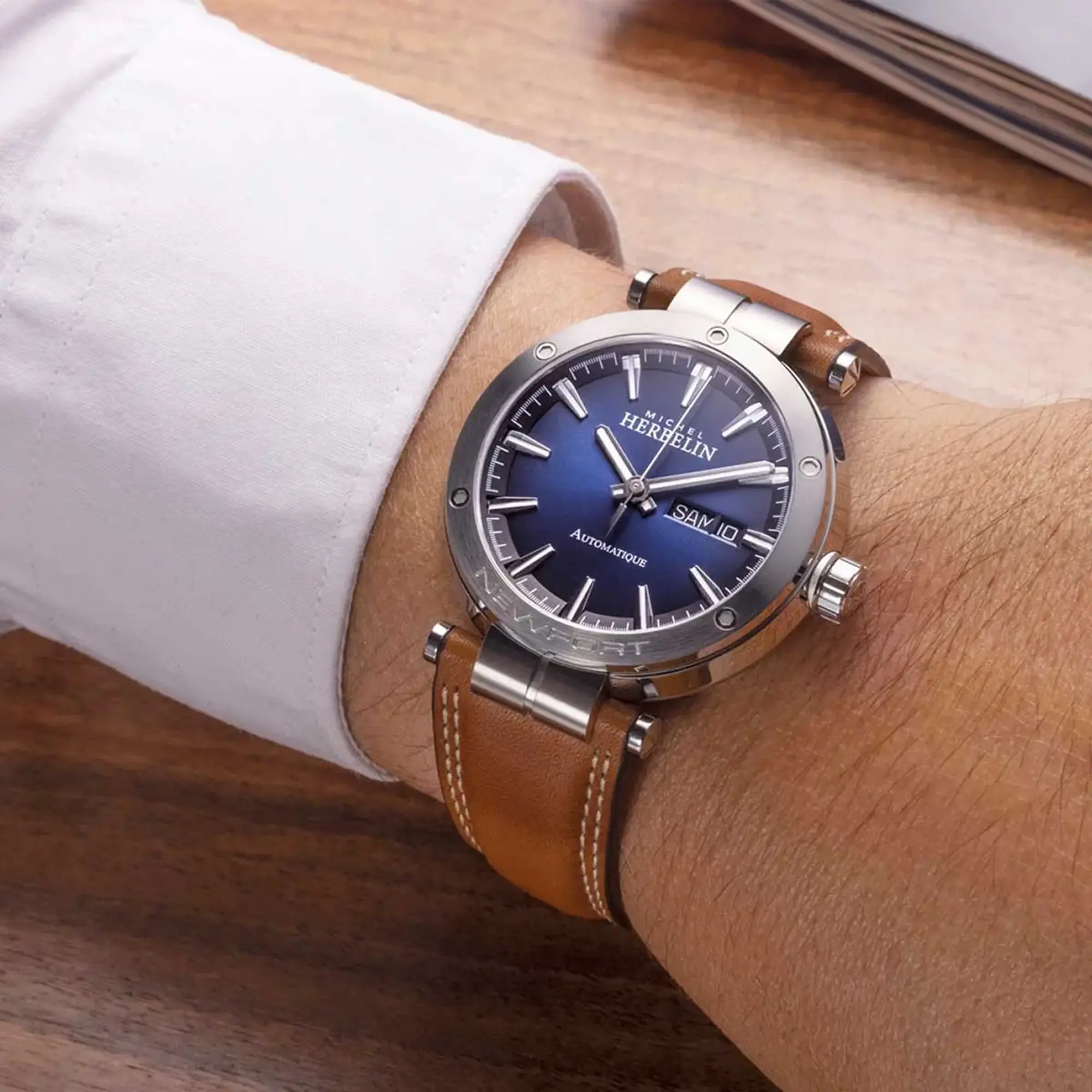 Au poignet masculin, cadran dégradé noir bleu et bracelet cuir visibles