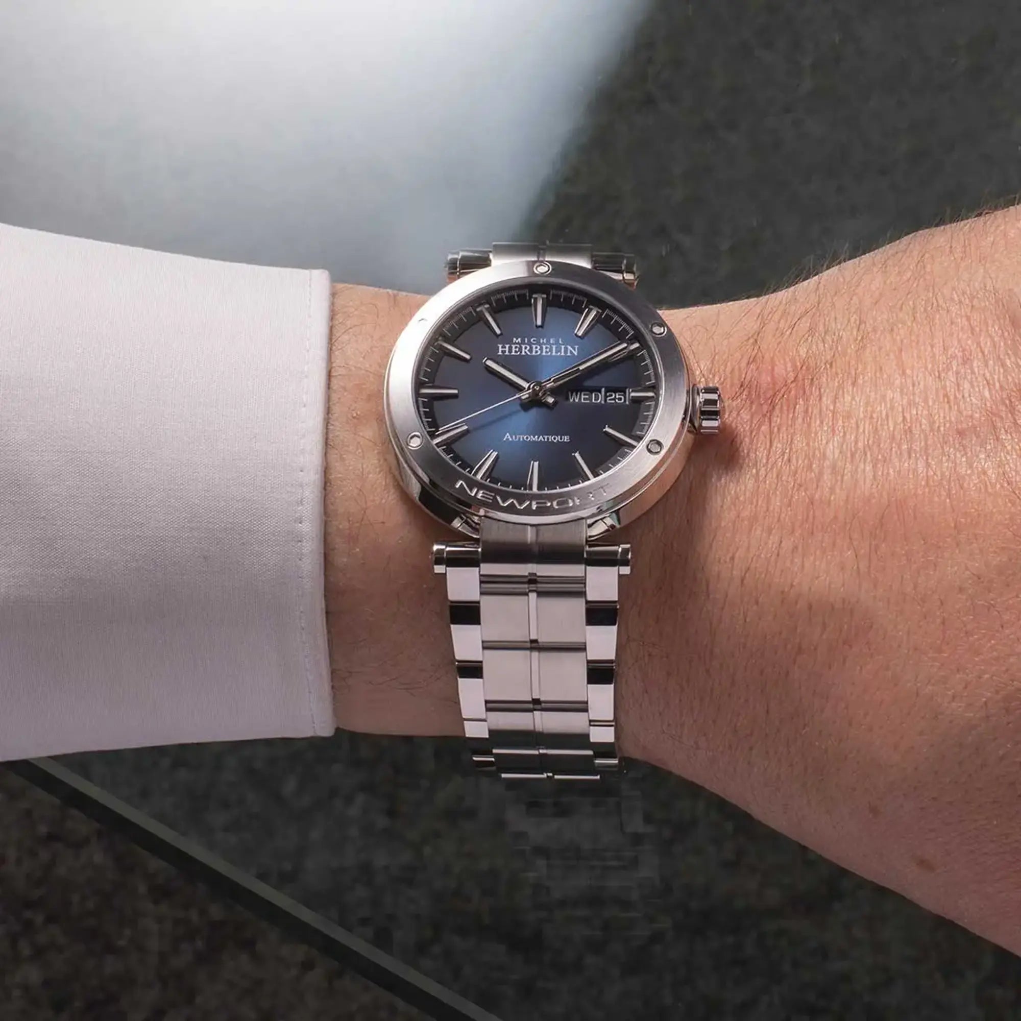 Au poignet masculin, cadran dégradé noir bleu et bracelet acier visibles