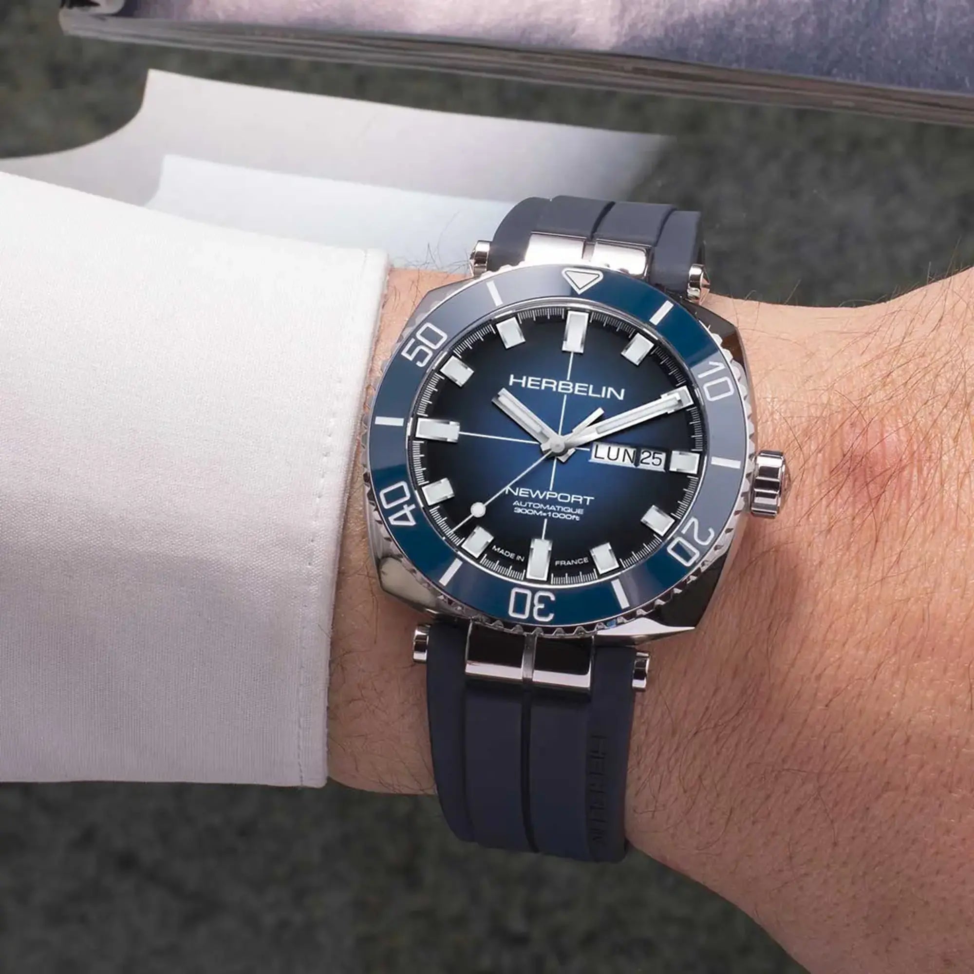 Au poignet masculin, cadran dégradé noir bleu et bracelet caoutchouc visibles