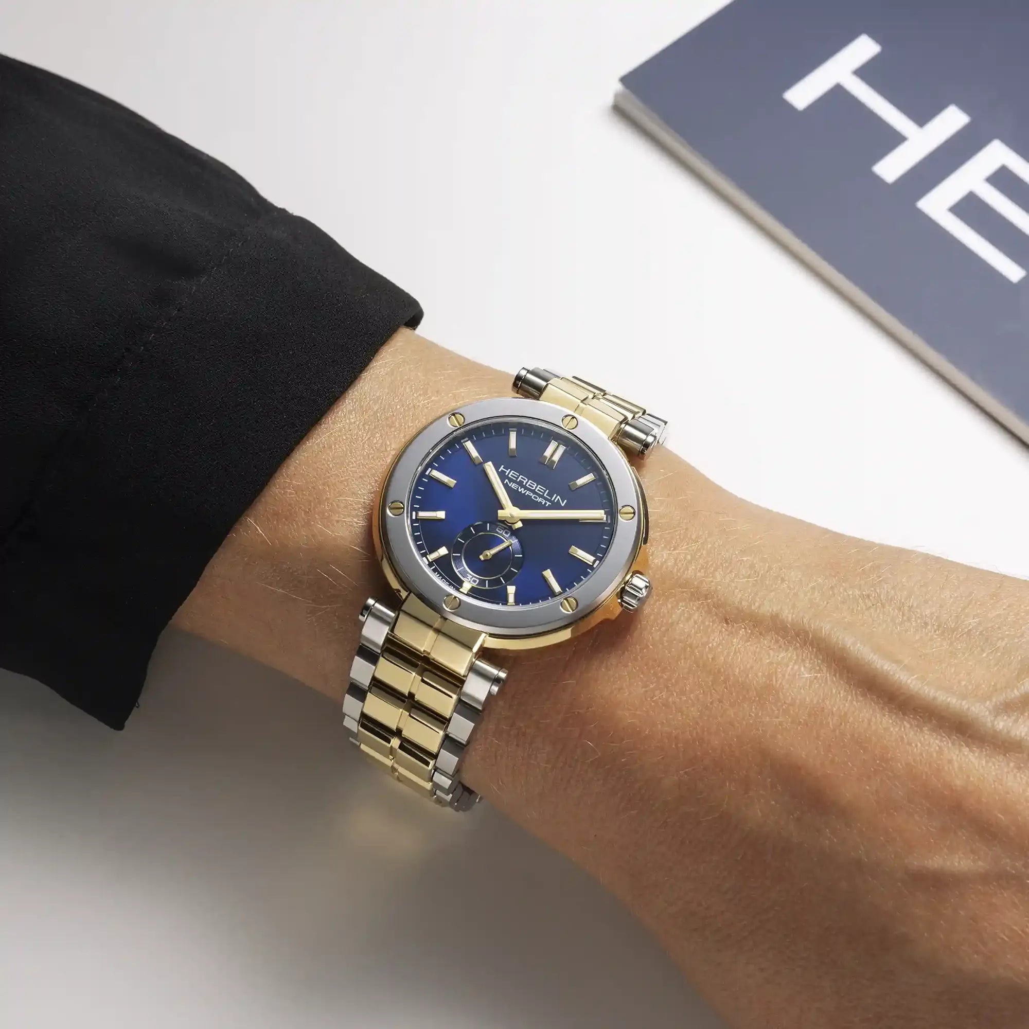 Au poignet féminin, cadran bleu et bracelet acier bicolore visibles