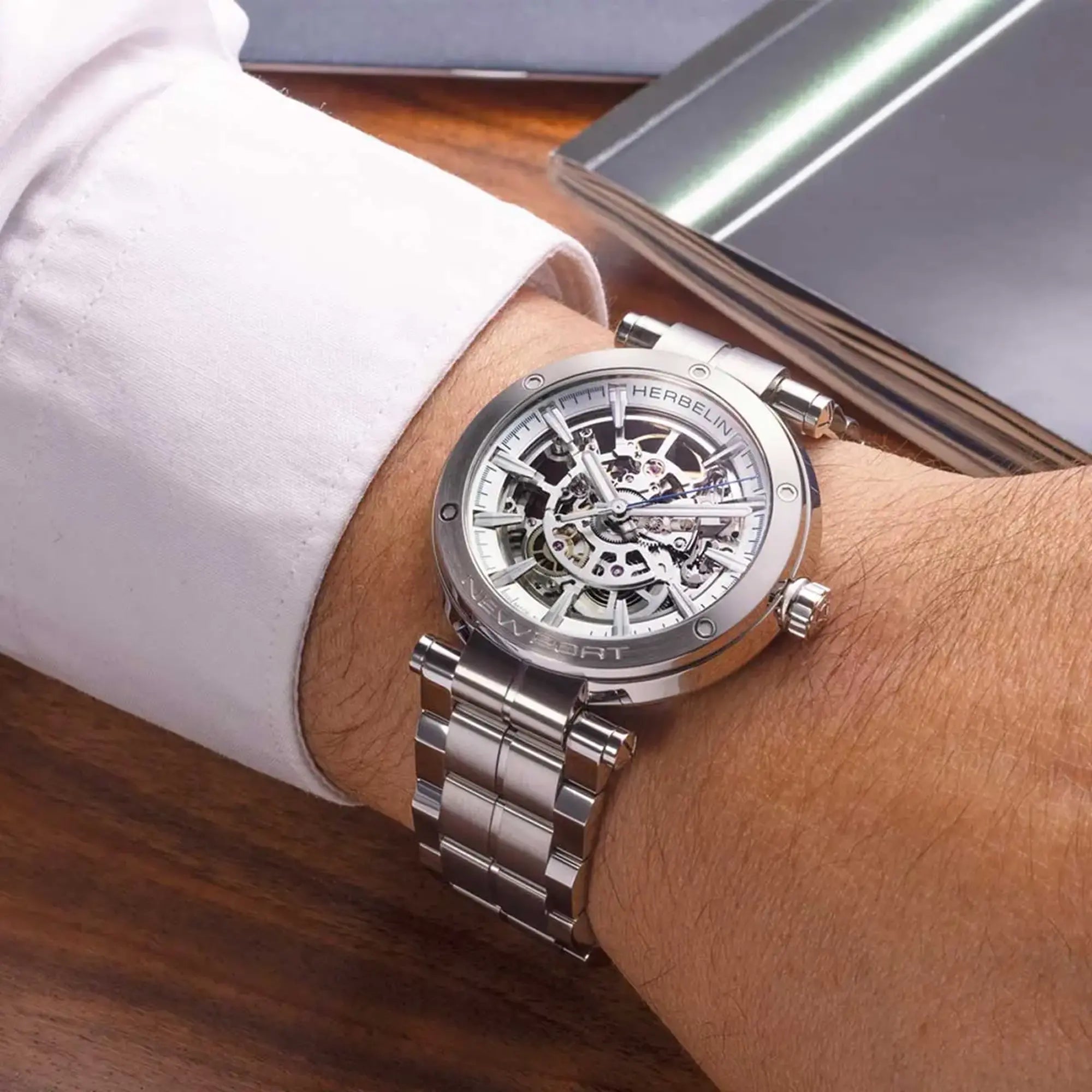Au poignet masculin, cadran argent blanc brossé et bracelet acier visibles