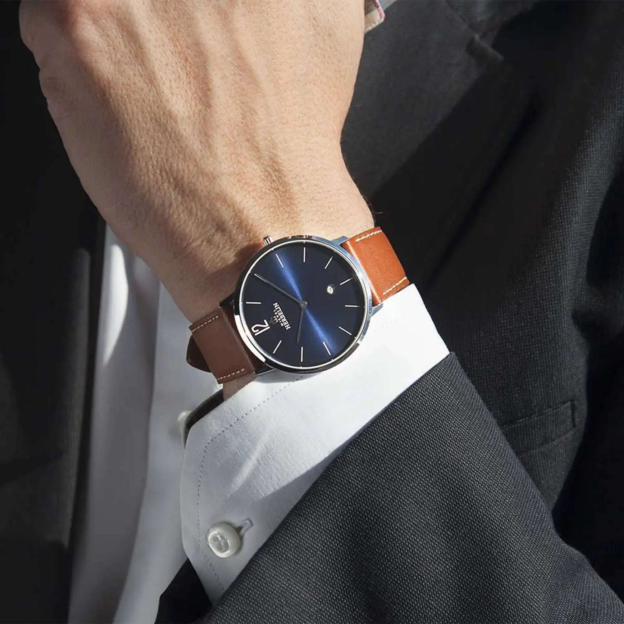 Au poignet masculin, cadran bleu et bracelet cuir visibles