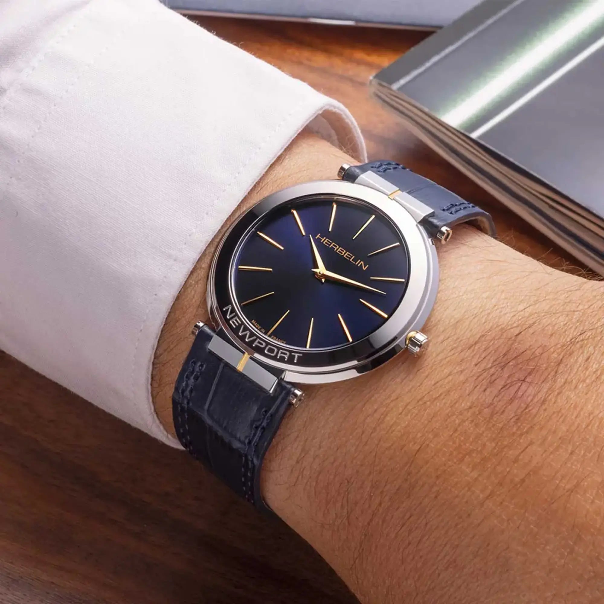 Au poignet masculin, cadran bleu profond et bracelet cuir visibles