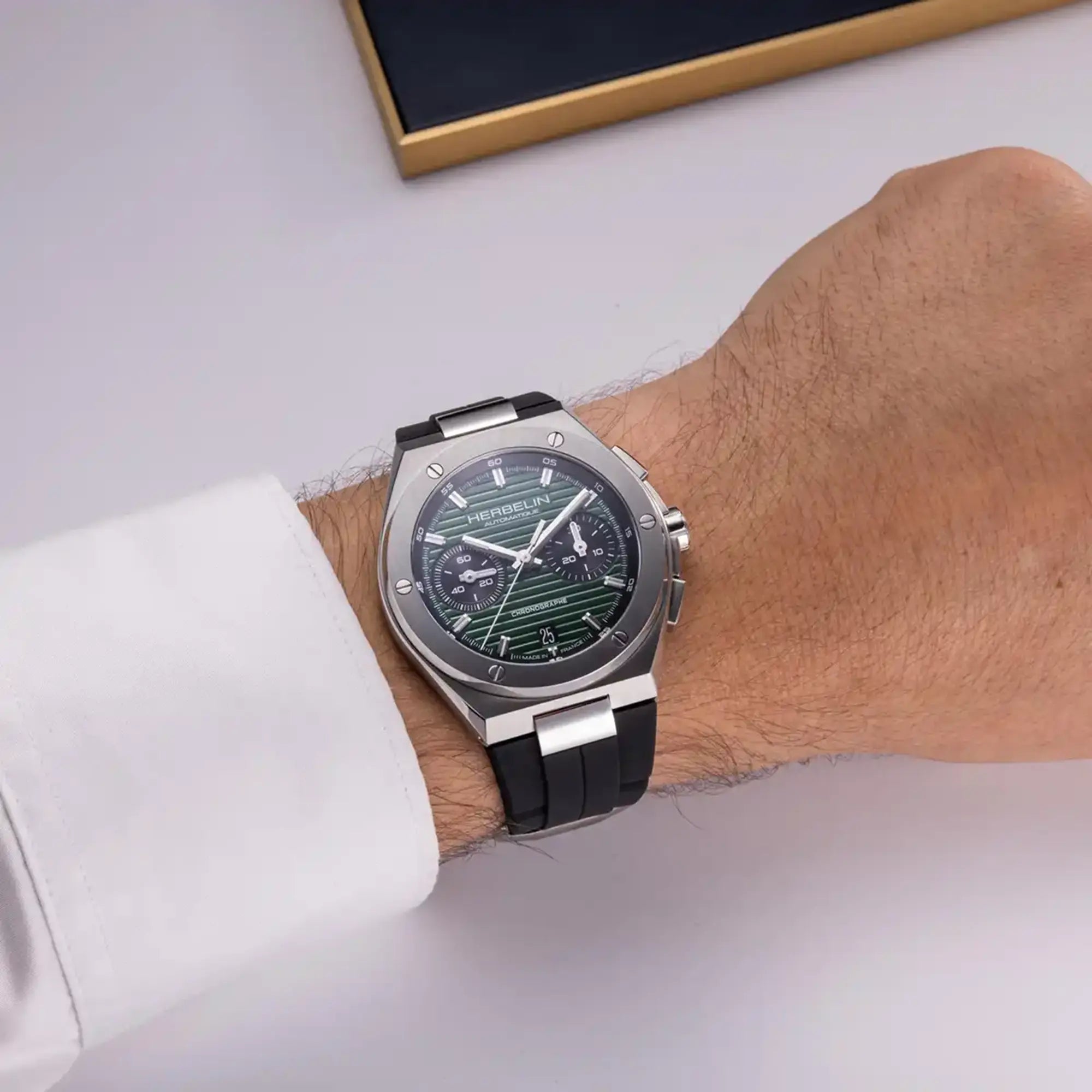 Au poignet masculin, cadran noir et bracelet caoutchouc visibles