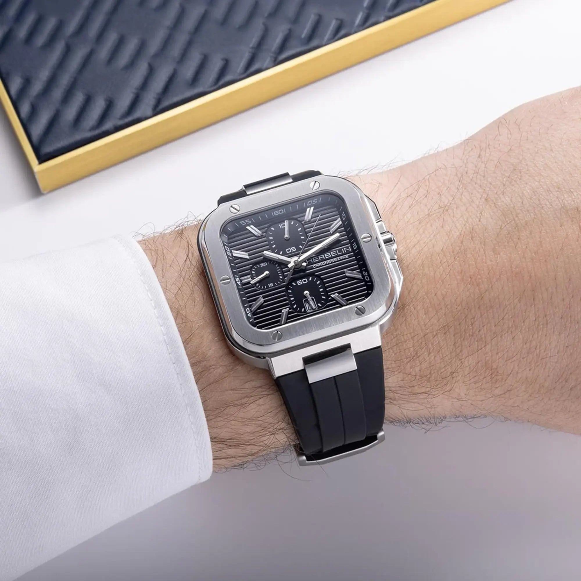 Au poignet masculin, cadran noir et bracelet caoutchouc visibles