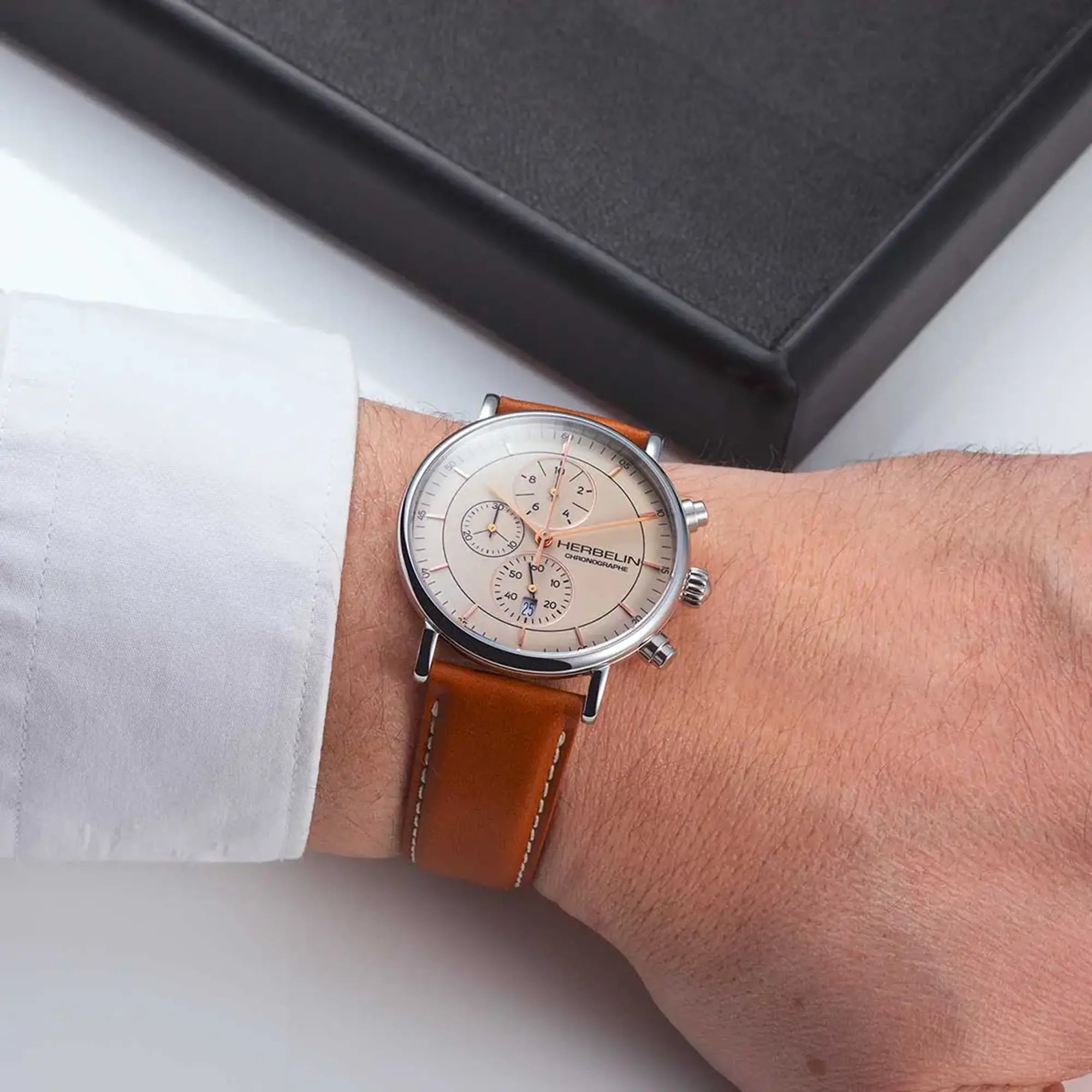Au poignet masculin, cadran coquille d'œuf et bracelet cuir visibles