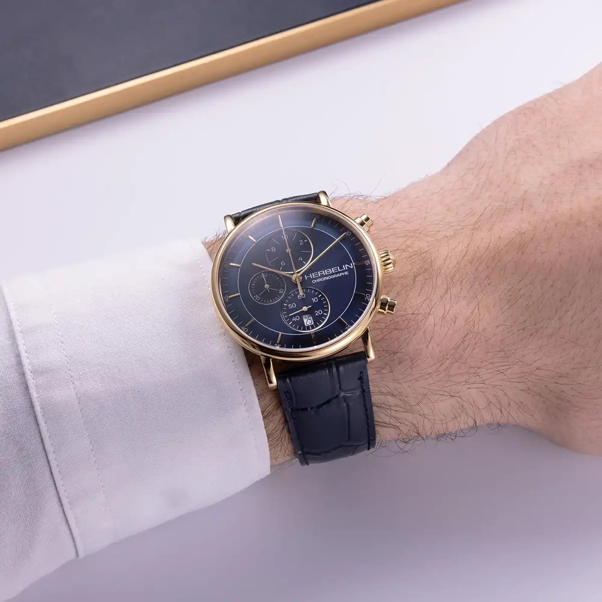 Au poignet masculin, cadran bleu et bracelet cuir visibles