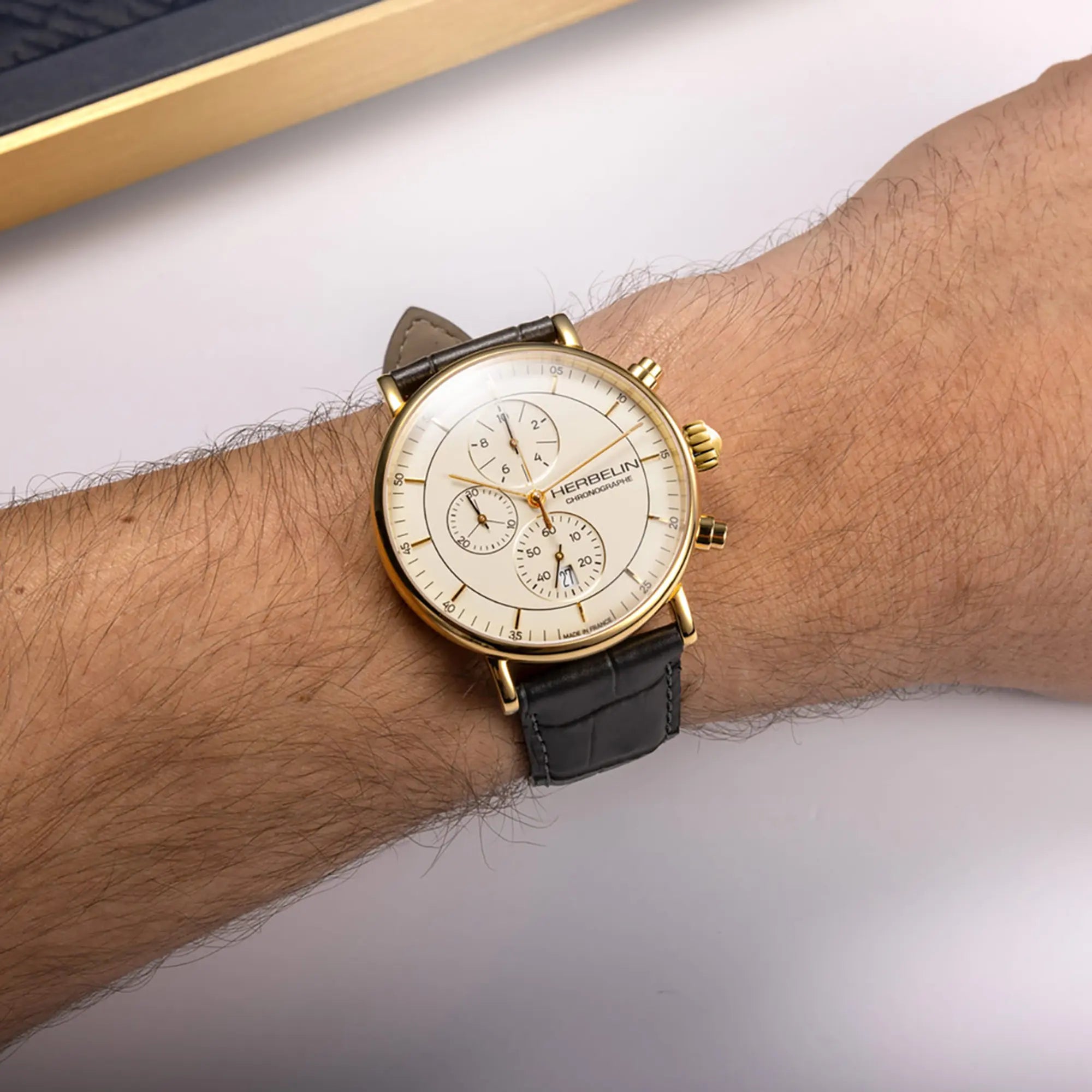 Au poignet masculin, cadran coquille d'œuf et bracelet cuir visibles