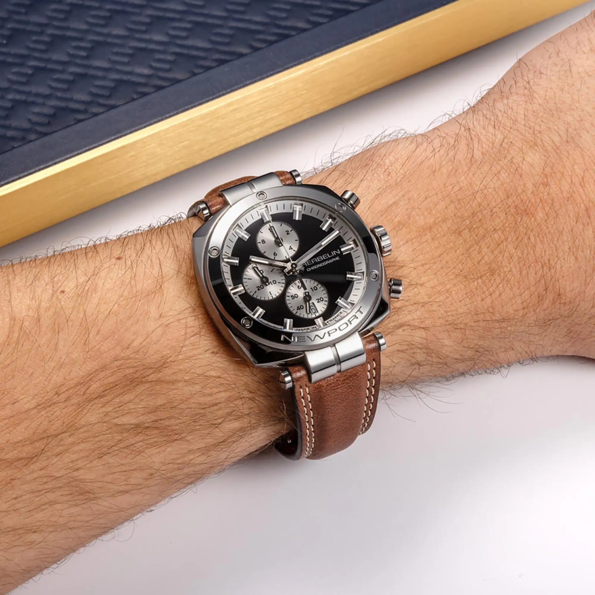 Au poignet masculin, cadran noir et bracelet cuir visibles