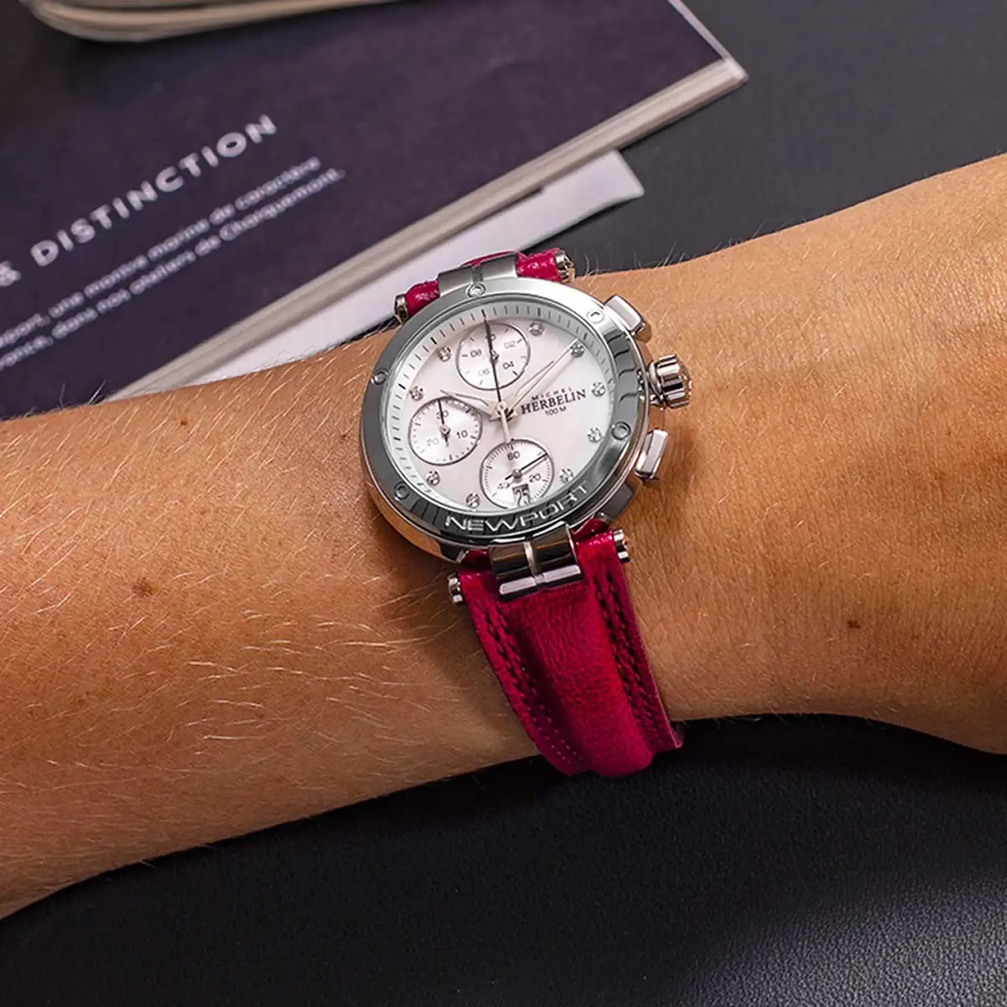 Au poignet féminin, cadran nacre blanche et bracelet cuir visibles