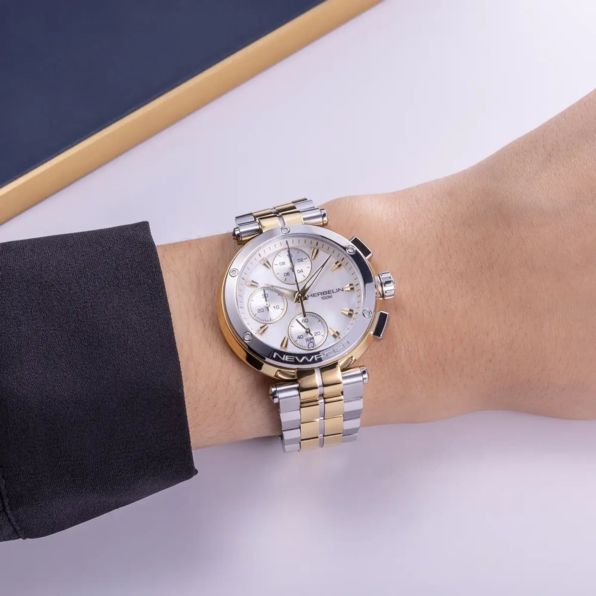 Au poignet féminin, cadran nacre blanche et bracelet acier bicolore visibles