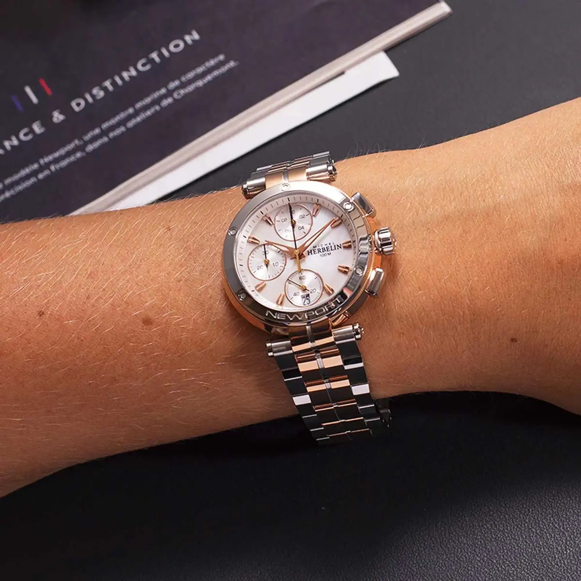 Au poignet féminin, cadran nacre blanche et bracelet acier PVD or rose visibles
