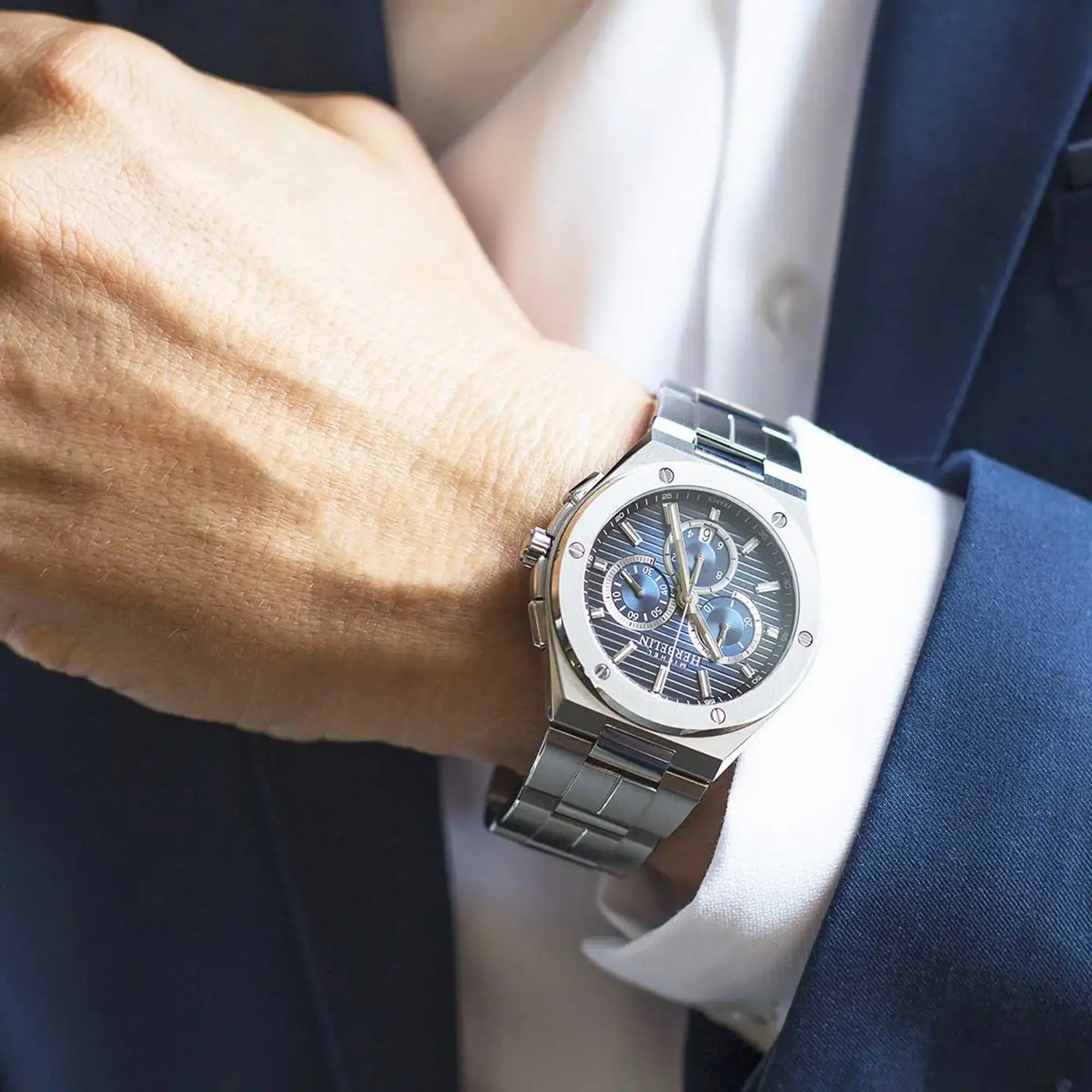Au poignet masculin, cadran bleu dégradé et bracelet acier visibles