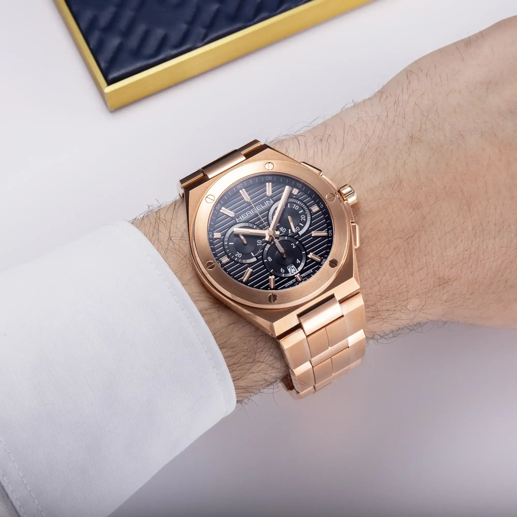 Au poignet masculin, cadran noir et bracelet acier PVD or rose visibles