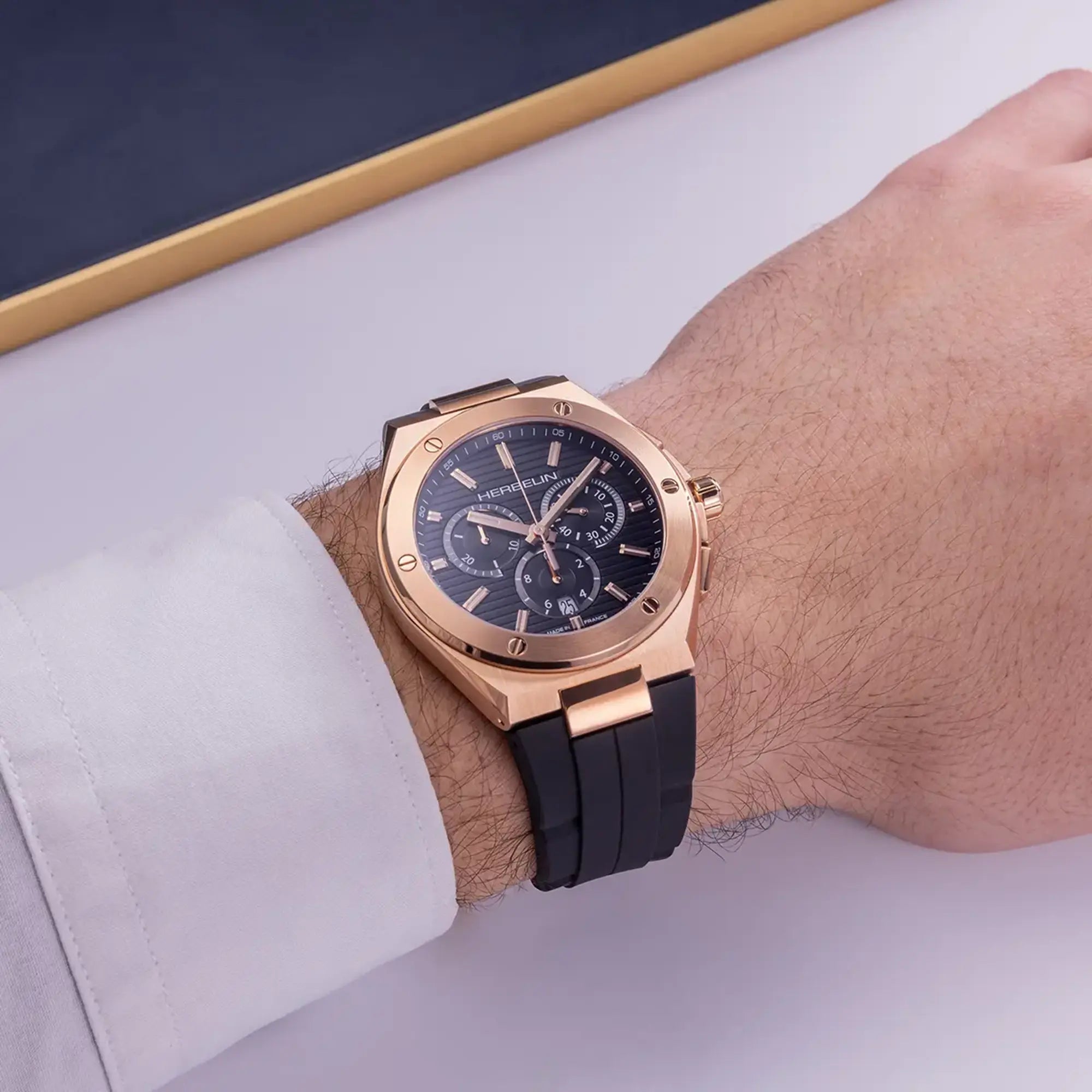 Au poignet masculin, cadran noir et bracelet caoutchouc visibles