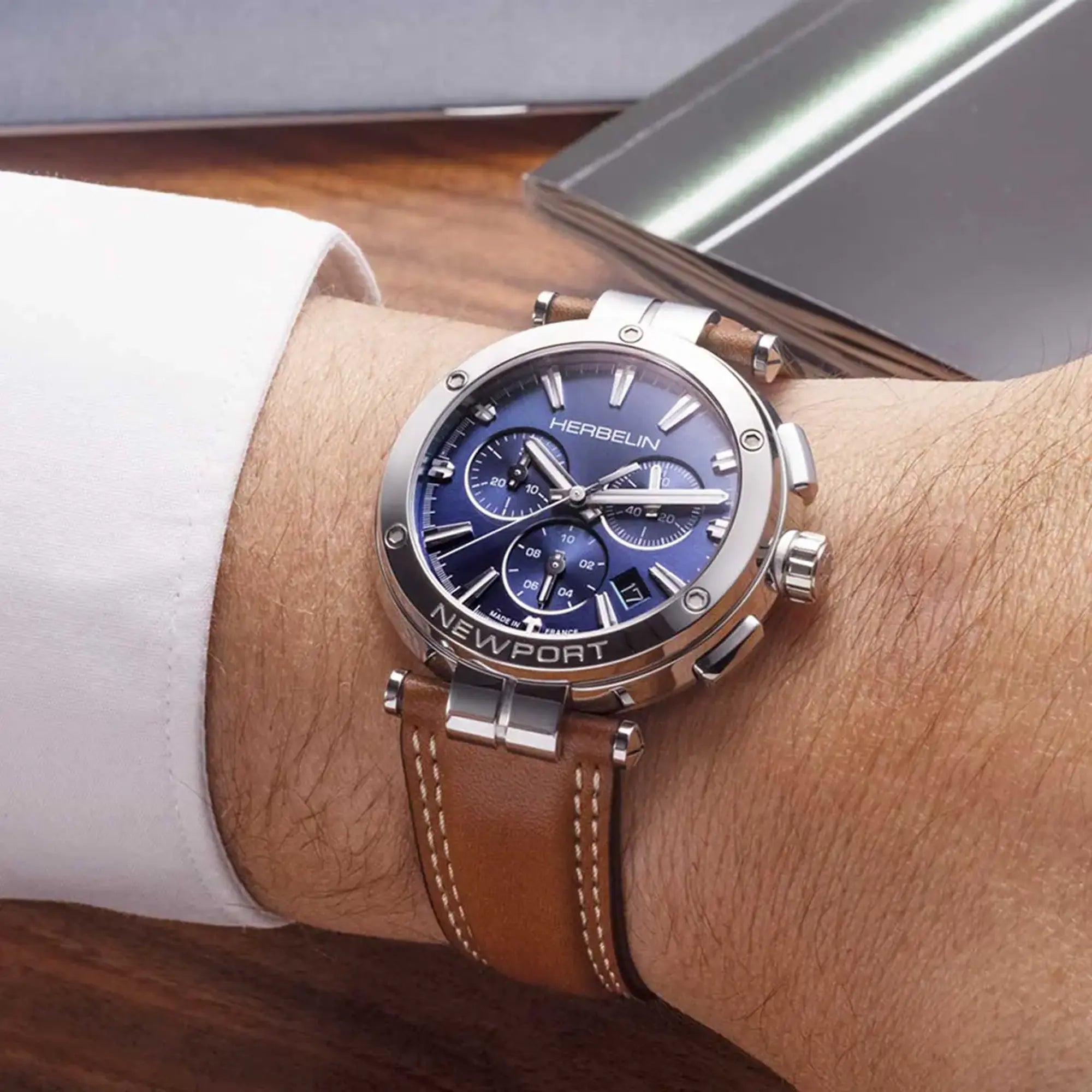 Au poignet masculin, cadran bleu et bracelet cuir visibles