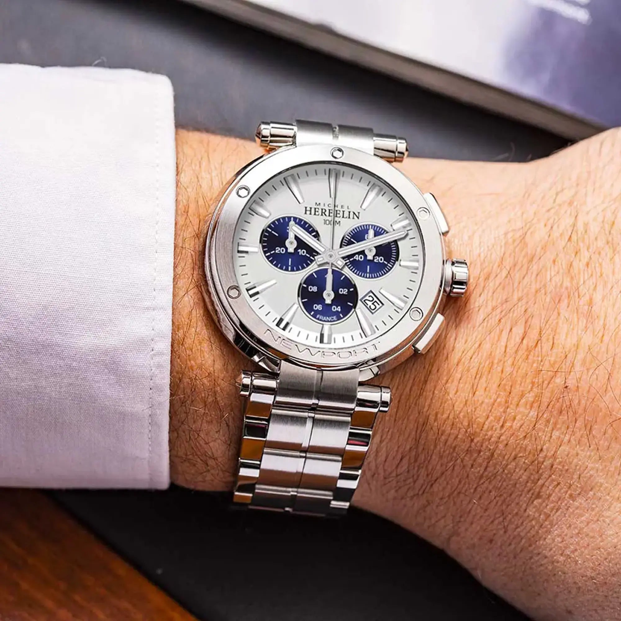 Au poignet masculin, cadran argent blanc brossé et bracelet acier visibles