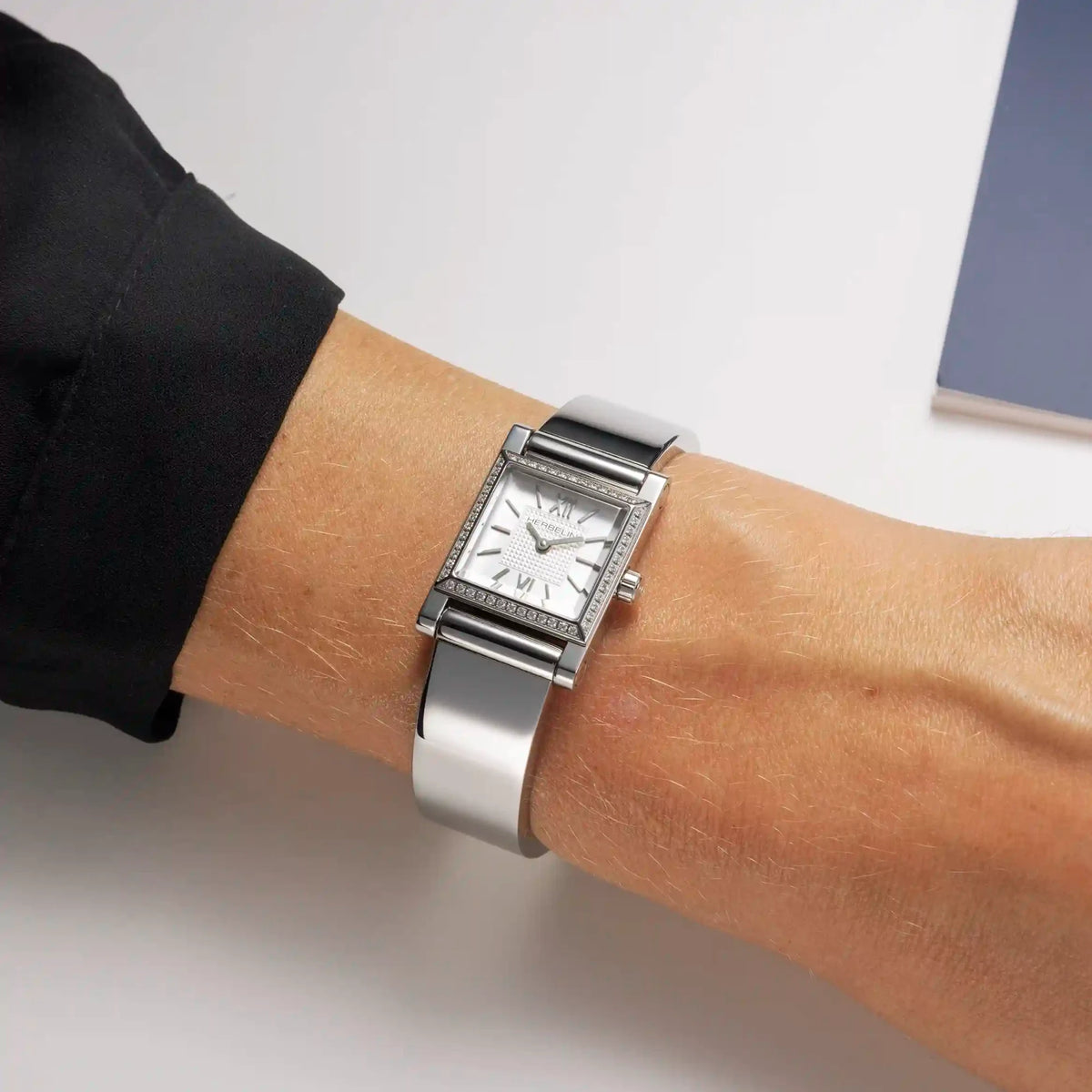 ⁣⁢Al polso femminile, bracciale bangle in acciaio con cassa Antarès incastonata⁤⁣