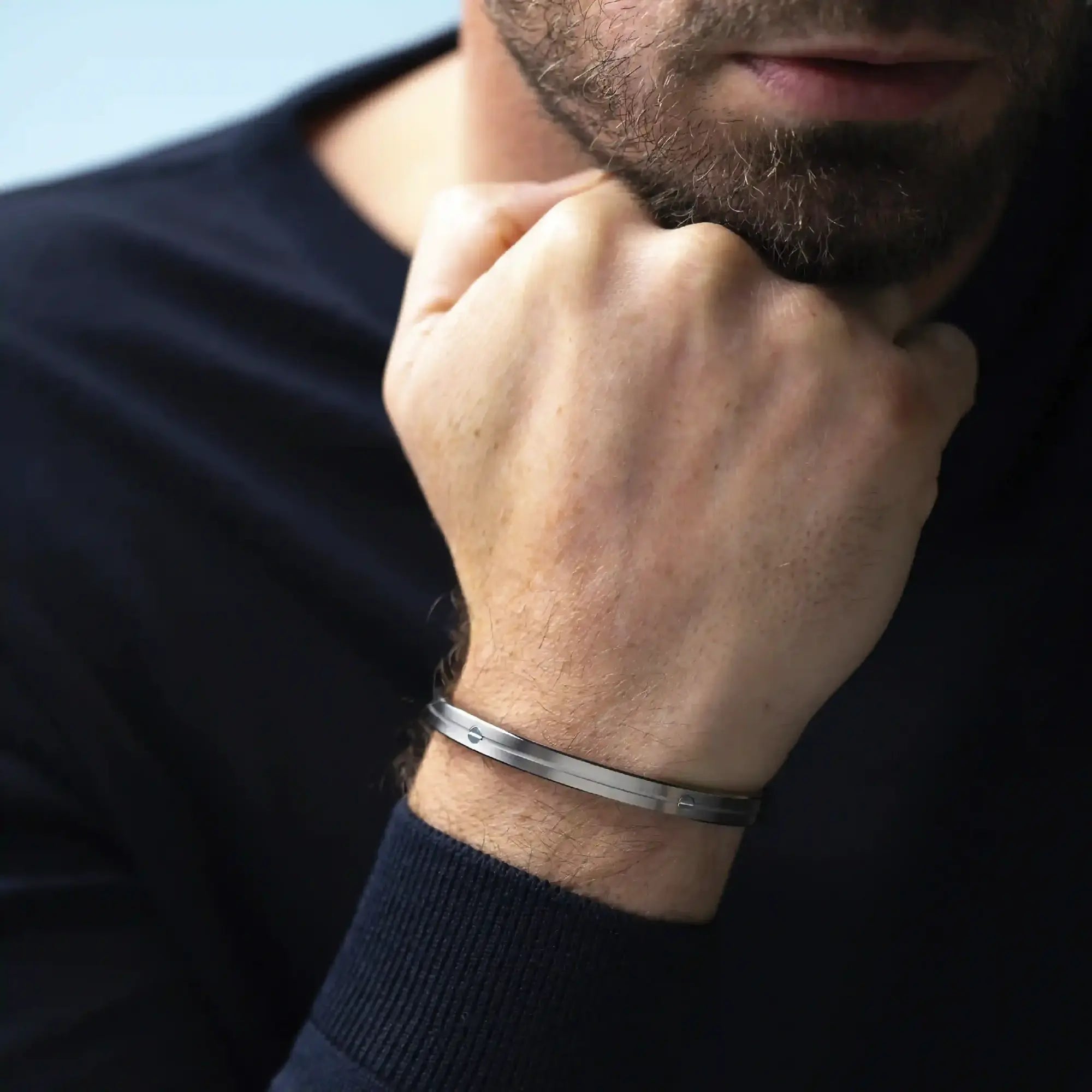 ⁣⁢Armring båret på et mands håndled, stål synlig⁤⁣