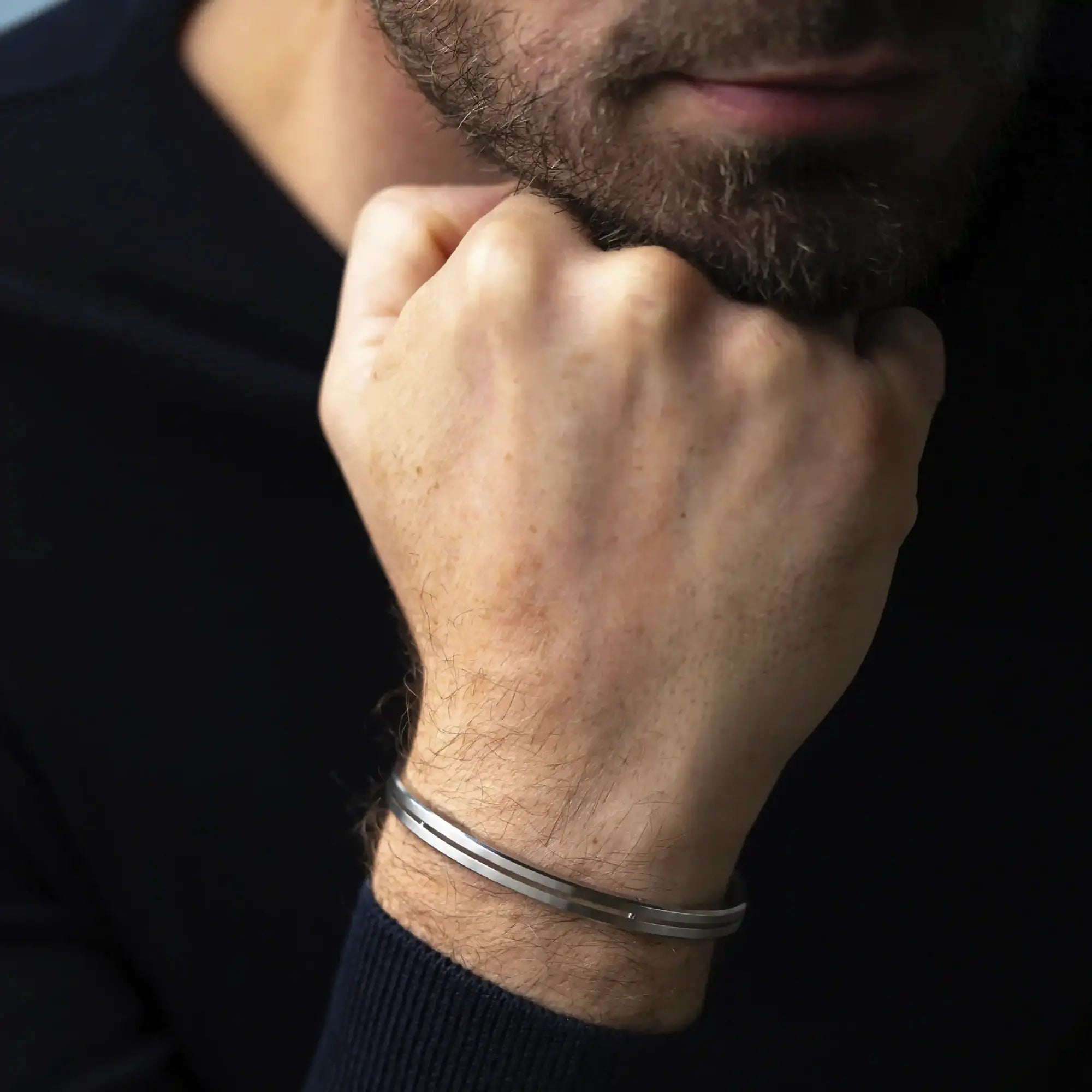 ⁣⁢Armring båret på et mands håndled, stål synlig⁤⁣