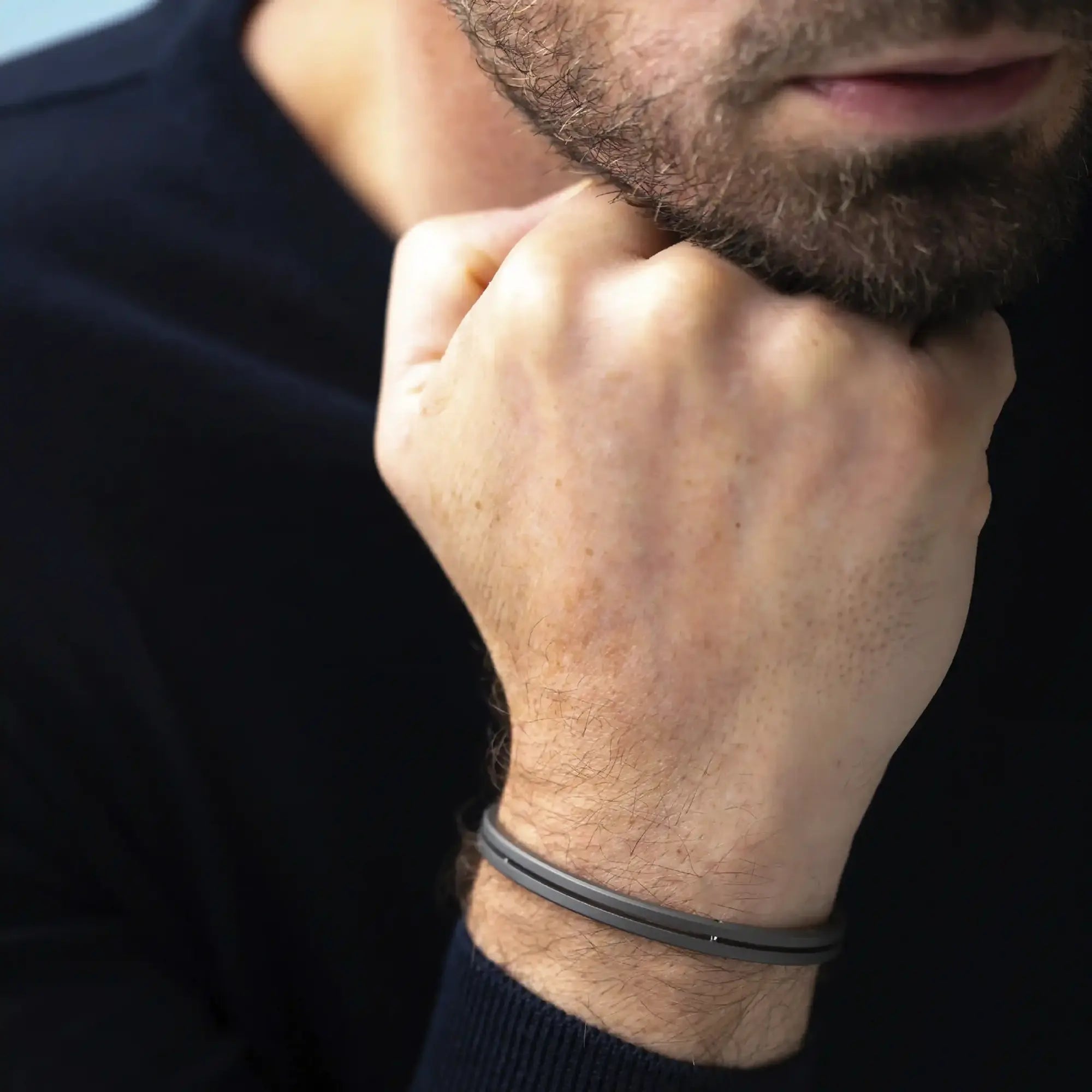 ⁣⁢Armring båret på et mands håndled, titanium synlig⁤⁣